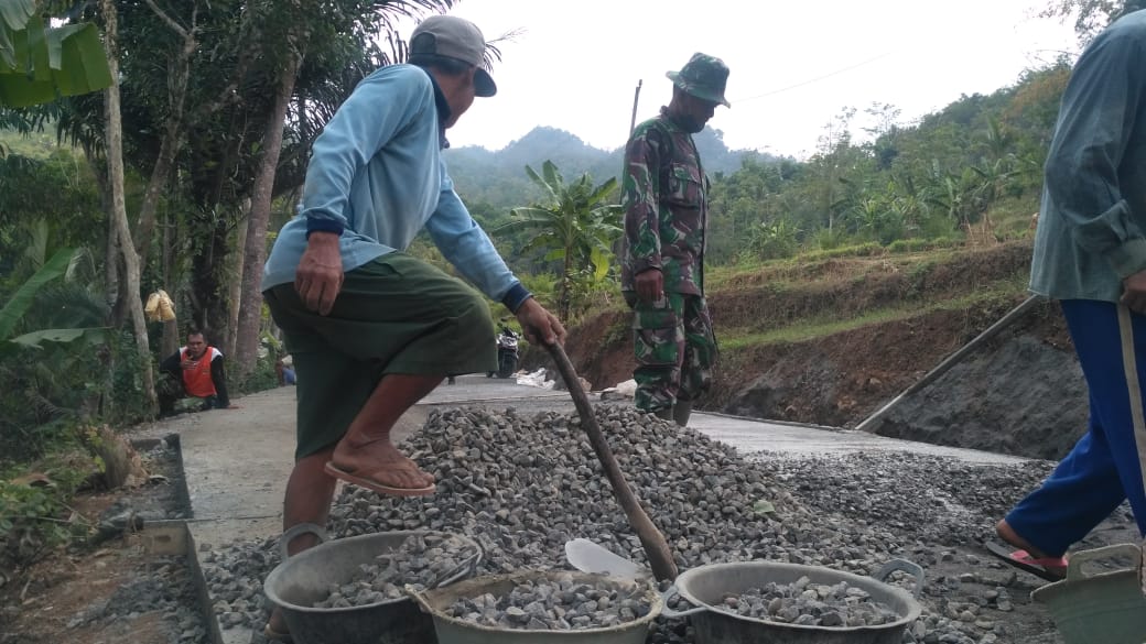 Anggota Satgas TMMD dan Warga Bersihkan Sisa Material di Badan Jalan