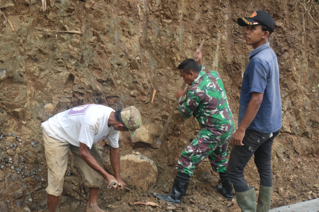 Anggota Koramil 11/ Loano Serma Wiwit Jinakan Batu Untuk Saluran Air Paska TMMD