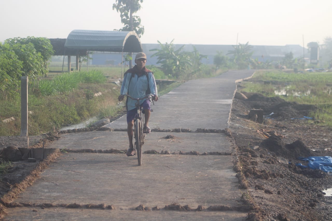 Sangat Menikmati Perjalanan, Terlihat Satu Warga Melintas Di Jalan Yang Baru Dibangun