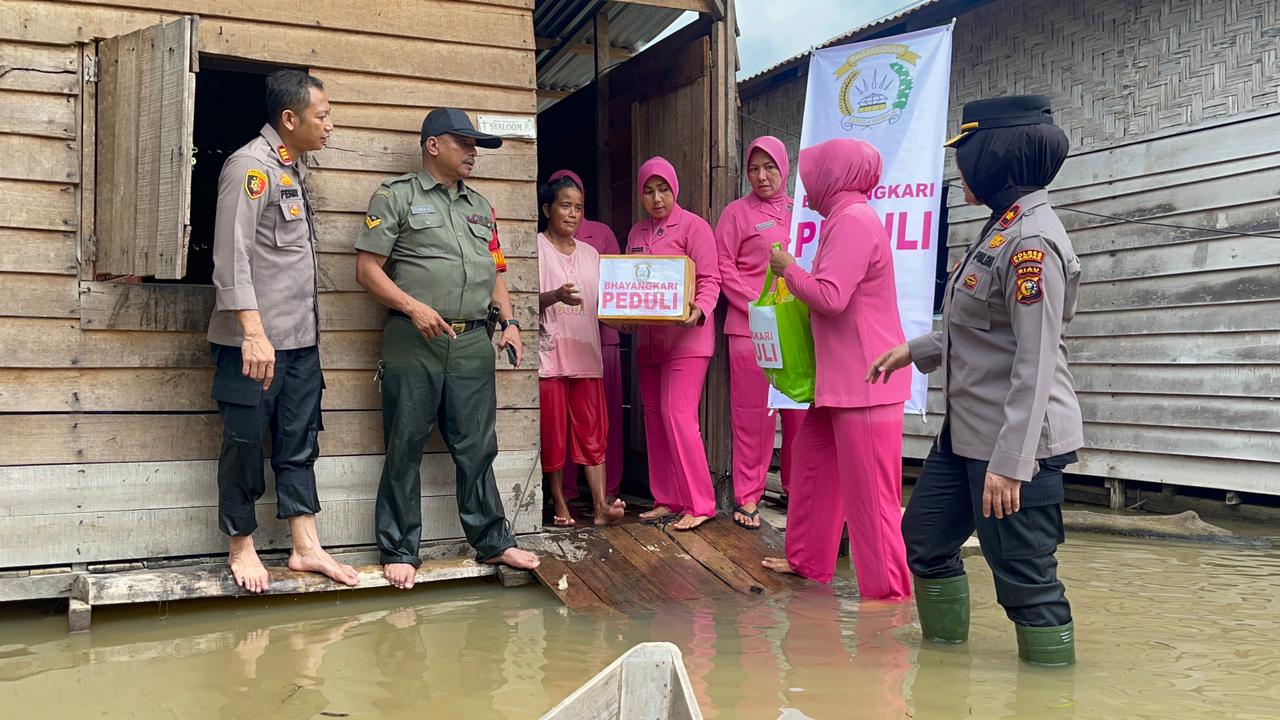 Arungi Banjir, Kapolsek Tapung Ulurkan Bantuan Kemanusiaan Kepada Masyarakat